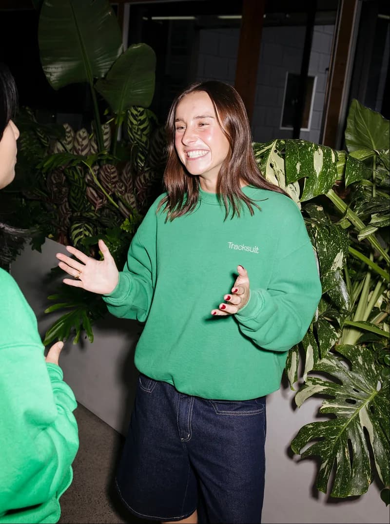 Tracksuit team member smiling among plants