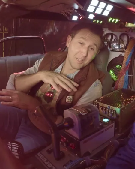 A man explaining from the driver's seat of a DeLorean time machine